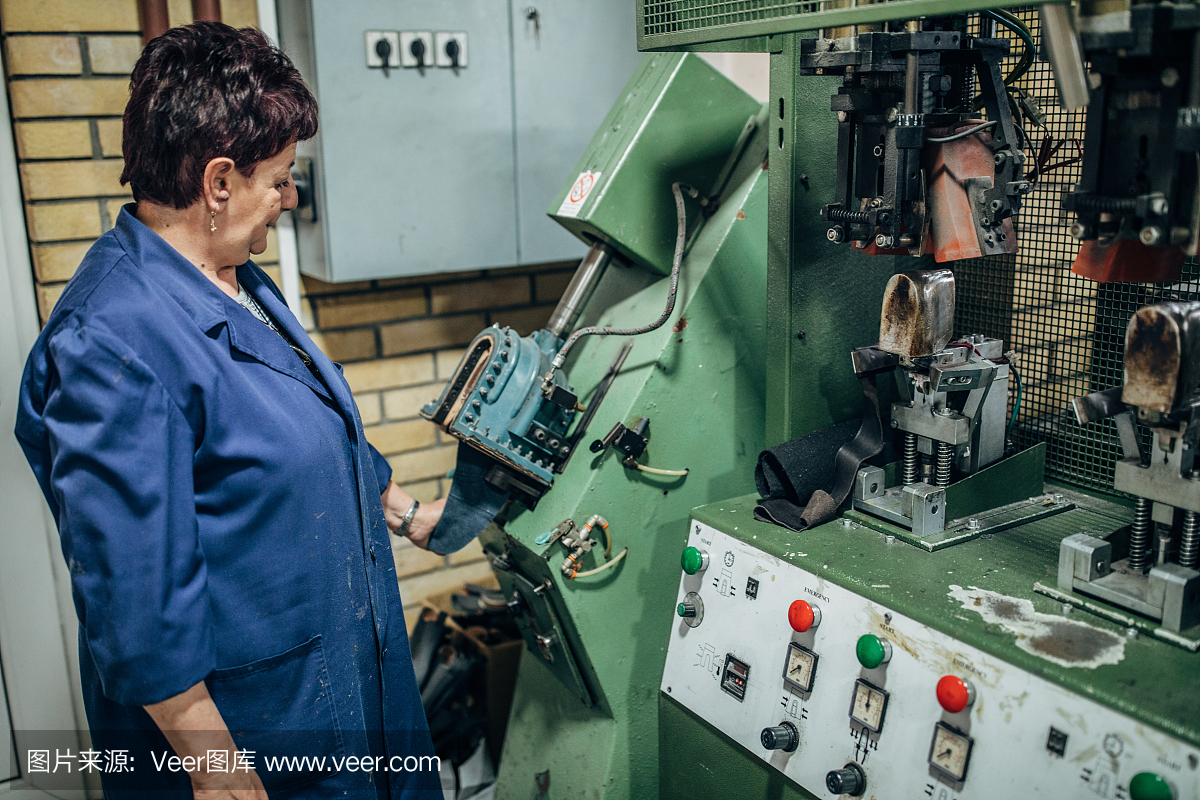 成熟的女人在鞋厂的机器上工作